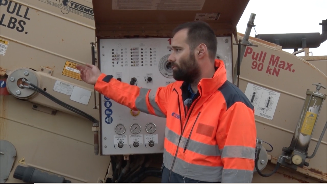 Man in PPE pointing at large machinery